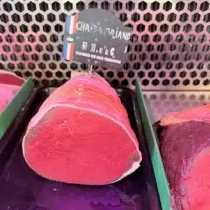 Morceau de bœuf Chateaubriand cru exposé en vitrine de boucherie avec étiquette française.