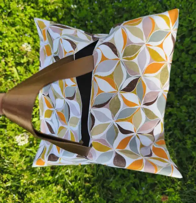 Sac à tarte 1 Sac cabas à motifs avec anses marron posé sur l'herbe verte, vu du dessus.