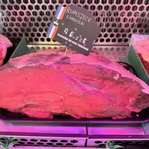 Rumsteck Limousin présenté en vitrine de boucherie avec étiquette de prix, viande rouge de qualité.