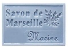 Savon de Marseille bleu marine, motif branche, posé sur une surface claire, savon artisanal naturel.