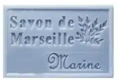 Savon de Marseille bleu marine, motif branche, posé sur une surface claire, savon artisanal naturel.
