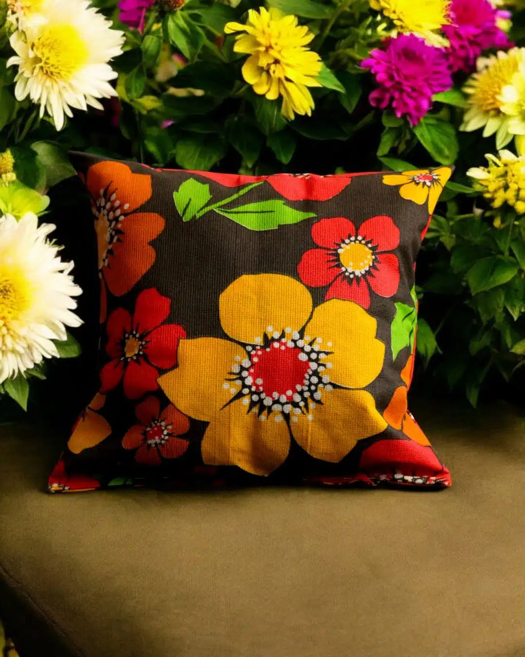 Coussin floral multicolore extérieur 2 Coussin carré à motif fleuri coloré parmi des fleurs jaunes, blanches et violettes en pleine floraison.