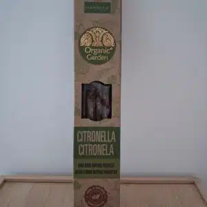 Boîte rectangulaire d'encens Nandita Citronella posée sur une table en bois, mur blanc, produit naturel anti-moustiques.