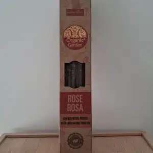 Boîte marron d’encens « Organic Garden Rose Rosa » posée sur un socle en bois, devant un mur, produit artisanal bio.