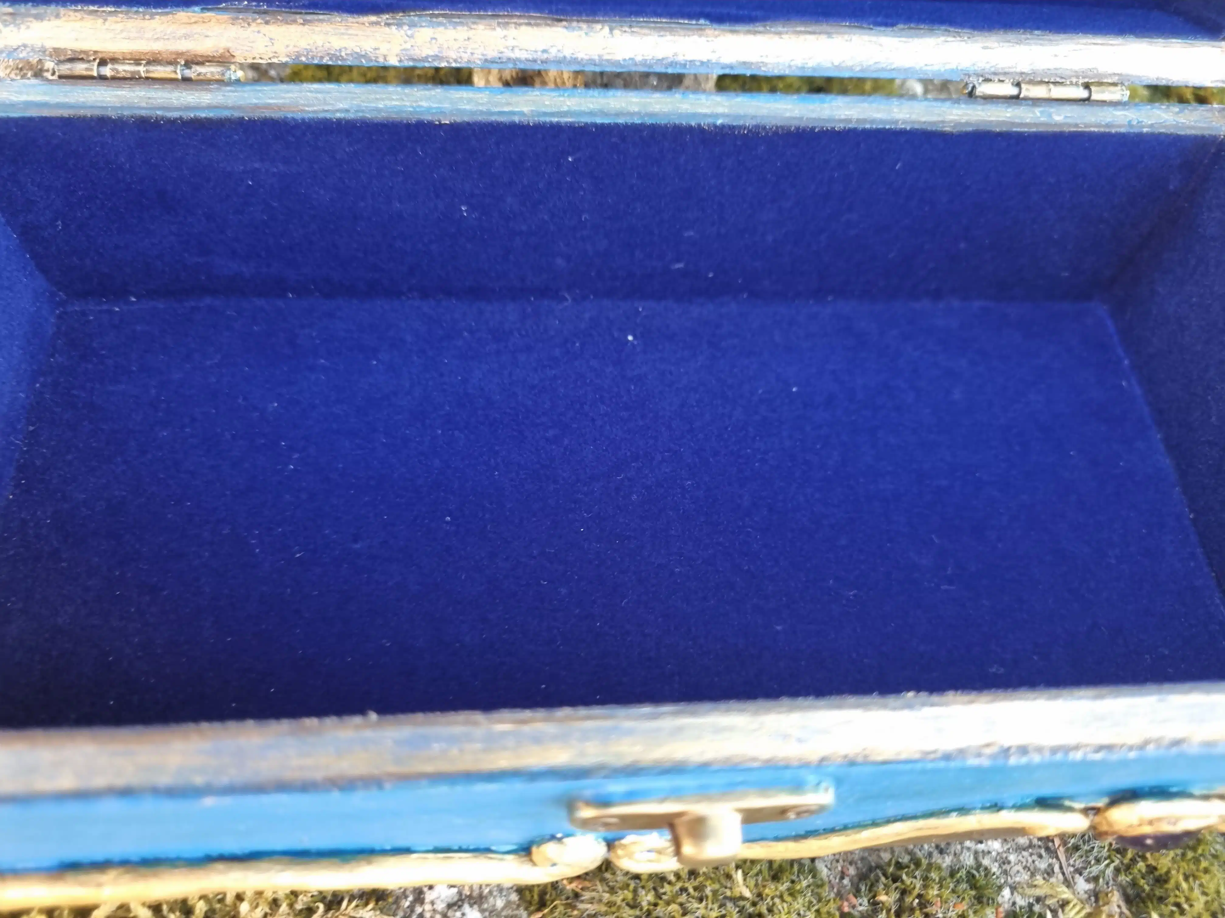 Coffret décoratif bleu & or – Cristaux – Pièce unique artisanale 13 Boîte vide doublée de velours bleu et bordée d’or, ouverte sur l’herbe en plein jour.