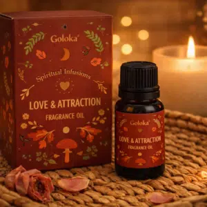 Accueil 10 Flacon et coffret d’huile parfumée Goloka Love & Attraction posés sur un tapis, une bougie et des pétales de rose.