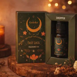 L'huile parfumée Goloka Fast Luck dans son coffret, posée près d'une bougie allumée.