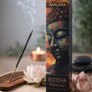 Boîte d’encens Banjara Buddha Harmony posée près d’un bâton d’encens allumé, de fleurs et d’une bougie.