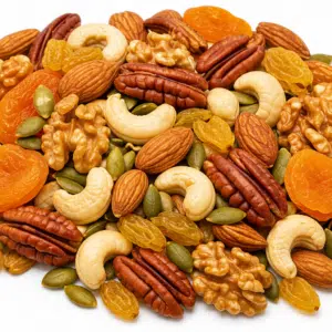 Mélange de noix, de graines de courge, de raisins secs et d'abricots secs, disposés en tas.