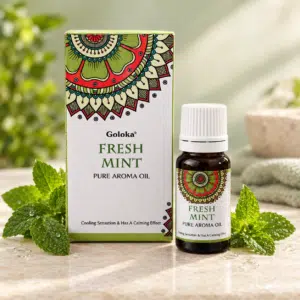 Accueil 11 Flacon d'huile essentielle Goloka Fresh Mint avec son emballage et des feuilles de menthe.
